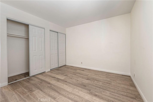 2051 Orizaba Ave Unit 8, Signal Hill, CA 90755 - unfurnished bedroom with multiple closets and wood finished floors