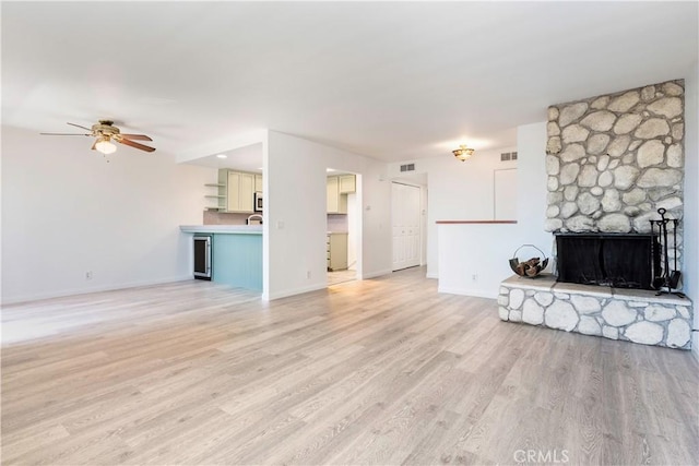 2051 Orizaba Ave Unit 8, Signal Hill, CA 90755 - unfurnished living room with a ceiling fan, light wood-style flooring, and a stone fireplace