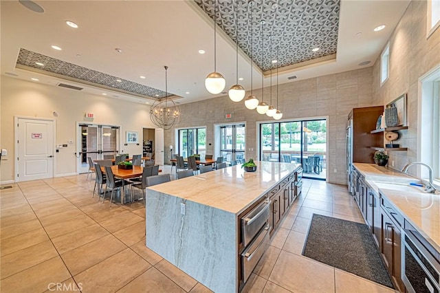 20754 W Bur Oak Cir, Porter Ranch, CA 91326 - kitchen featuring a raised ceiling, a high ceiling, light tile patterned floors, recessed lighting, and light countertops