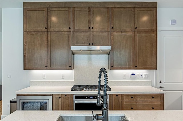 20754 W Bur Oak Cir, Porter Ranch, CA 91326 - kitchen featuring under cabinet range hood, appliances with stainless steel finishes, and light countertops