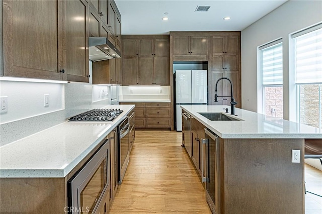 20754 W Bur Oak Cir, Porter Ranch, CA 91326 - kitchen with stainless steel appliances, range hood, light wood-style flooring, light countertops, and recessed lighting