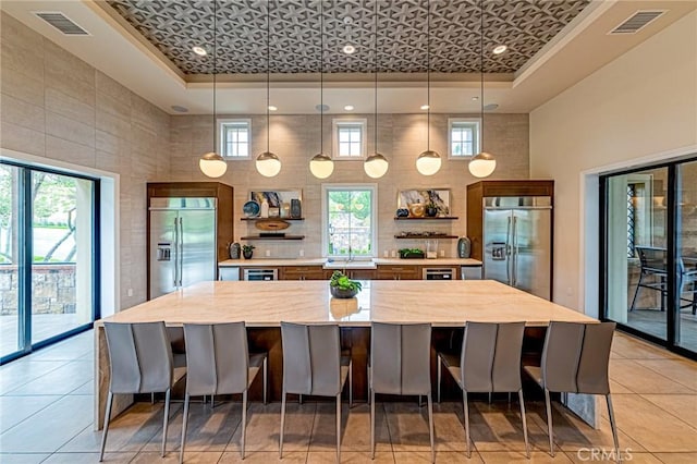 20754 W Bur Oak Cir, Porter Ranch, CA 91326 - kitchen with built in refrigerator, light countertops, a large island, a raised ceiling, and a towering ceiling