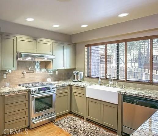 1709 Lassen Way, Pine Mountain Club, CA 93222 - kitchen featuring appliances with stainless steel finishes, under cabinet range hood, tasteful backsplash, light stone counters, and recessed lighting