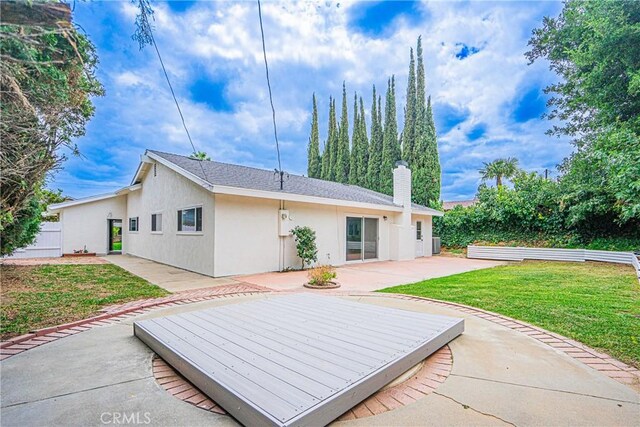 18259 Midbury St, Brea, CA 92821 - rear view of property featuring a chimney, a yard, stucco siding, and a patio