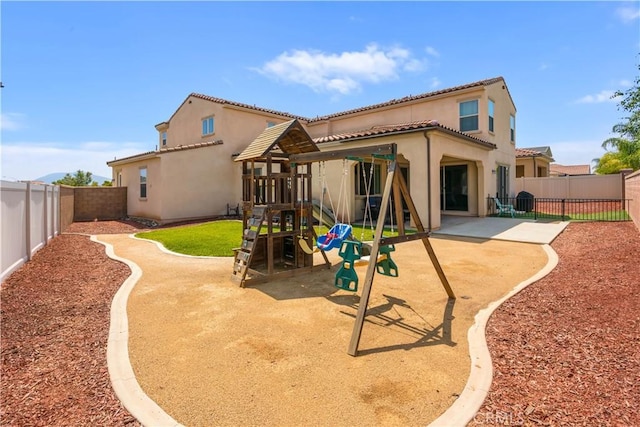 34901 Limecrest Pl, Murrieta, CA 92563 - back of house featuring a playground, stucco siding, a fenced backyard, a tiled roof, and a patio