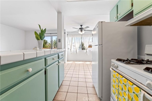 910 W 26th St Unit 3, San Pedro, CA 90731 - kitchen with white gas range oven, green cabinetry, light tile patterned floors, under cabinet range hood, and a ceiling fan