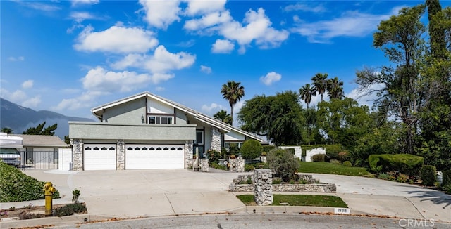 1938 N Quince Way, Upland, CA 91784 - mid-century inspired home with concrete driveway, stone siding, a gate, and a mountain view