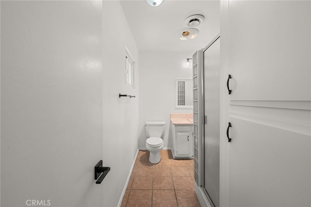 3221 W Jacinto View Rd, Banning, CA 92220 - bathroom featuring vanity, toilet, tile patterned floors, baseboards, and a shower with shower door