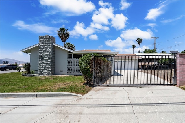 3221 W Jacinto View Rd, Banning, CA 92220 - view of front facade featuring a gate, stucco siding, concrete driveway, and a chimney