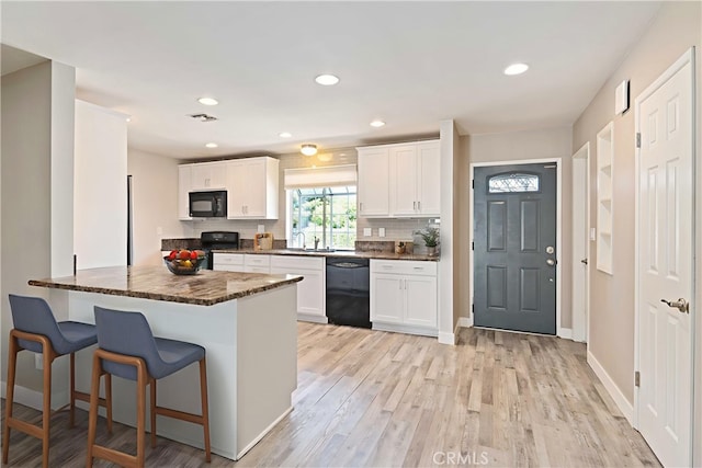 2241 Cordero Ave, Simi Valley, CA 93065 - kitchen with black appliances, a kitchen breakfast bar, white cabinets, a peninsula, and light wood finished floors