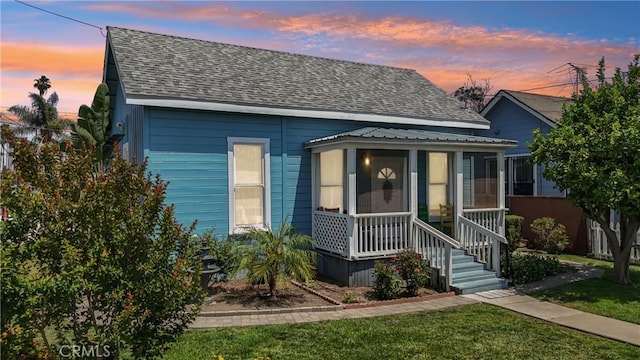382 N Palomares St, Pomona, CA 91767 - bungalow-style house featuring roof with shingles, a sunroom, and a front yard
