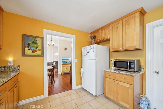 382 N Palomares St, Pomona, CA 91767 - kitchen featuring stainless steel microwave, freestanding refrigerator, a chandelier, and light stone countertops