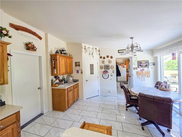 38727 State Highway 96, Klamath River, CA 96050 - kitchen with light countertops, brown cabinets, a chandelier, light marble finish flooring, and decorative light fixtures