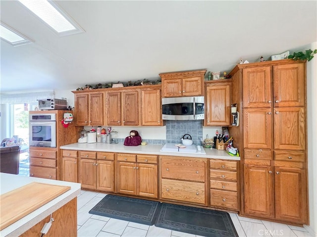 38727 State Highway 96, Klamath River, CA 96050 - kitchen featuring appliances with stainless steel finishes, light countertops, brown cabinetry, and light tile patterned floors