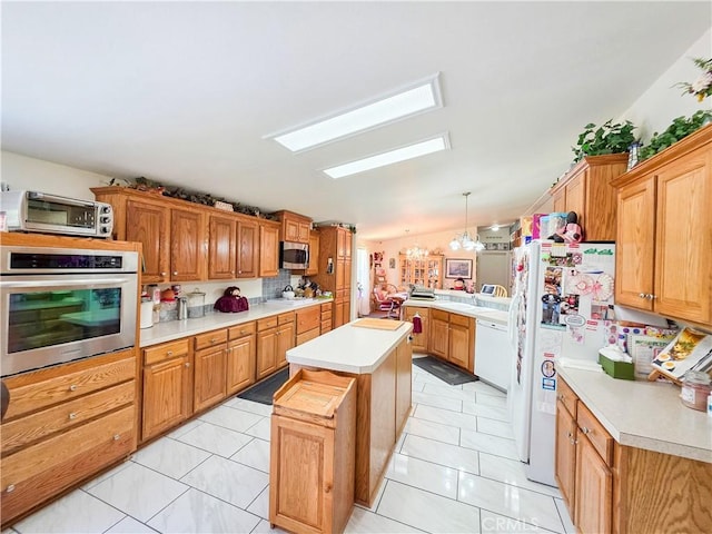 38727 State Highway 96, Klamath River, CA 96050 - kitchen featuring stainless steel appliances, a skylight, a center island, light countertops, and decorative light fixtures