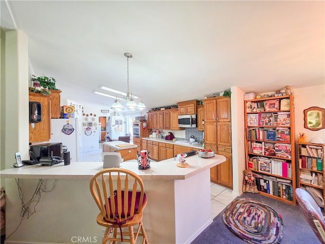 38727 State Highway 96, Klamath River, CA 96050 - kitchen with stainless steel appliances, light countertops, brown cabinetry, a peninsula, and a breakfast bar area
