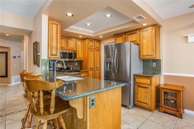 100 Waters Ct, Redlands, CA 92374 - kitchen with stainless steel appliances, dark stone countertops, a sink, backsplash, and recessed lighting