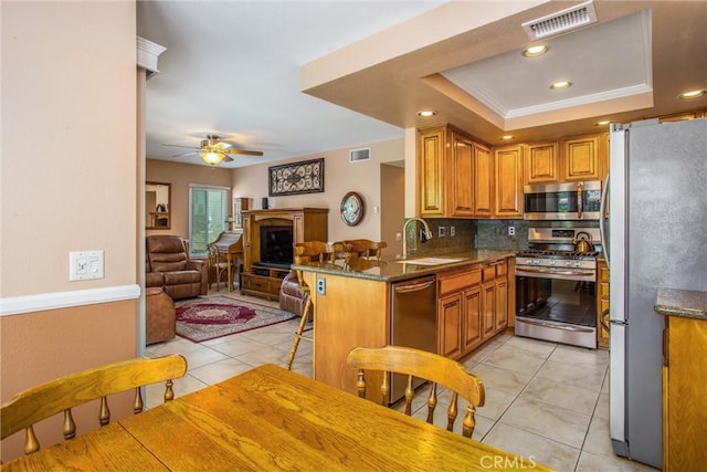 100 Waters Ct, Redlands, CA 92374 - kitchen featuring stainless steel appliances, a sink, light tile patterned floors, decorative backsplash, and open floor plan
