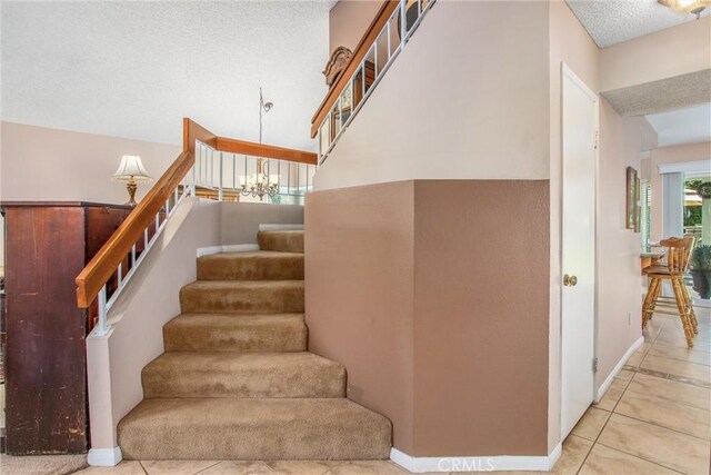 100 Waters Ct, Redlands, CA 92374 - staircase featuring a textured ceiling, tile patterned floors, and baseboards