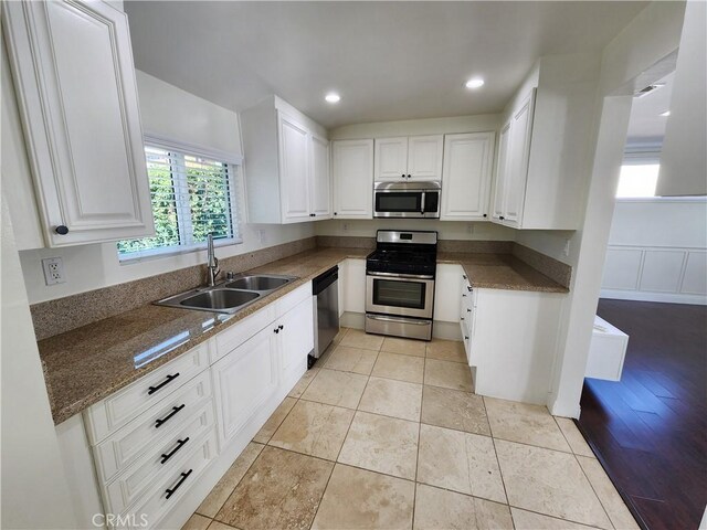 10450 Balboa Blvd, Granada Hills, CA 91344 - kitchen with appliances with stainless steel finishes, a sink, white cabinets, recessed lighting, and dark stone countertops