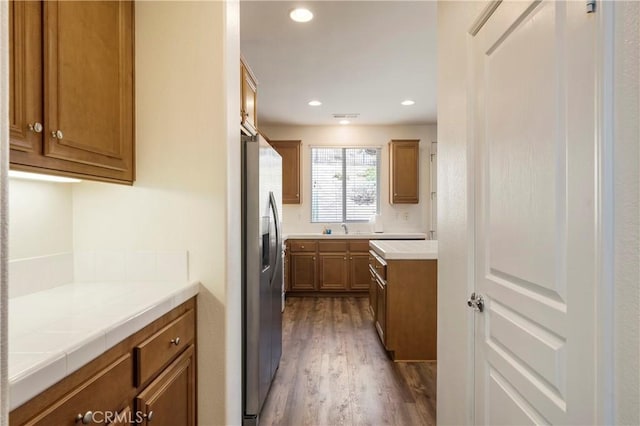 197 Inkster Way, Hemet, CA 92545 - kitchen with stainless steel fridge, dark wood-style floors, tile counters, brown cabinetry, and recessed lighting