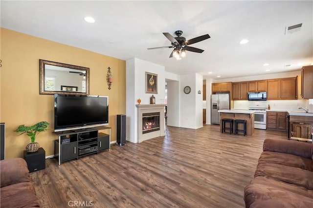 197 Inkster Way, Hemet, CA 92545 - living area with ceiling fan, dark wood finished floors, a glass covered fireplace, and recessed lighting