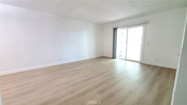 17070 Colima Rd Unit 284, Hacienda Heights, CA 91745 - empty room featuring a textured ceiling, light wood finished floors, and baseboards