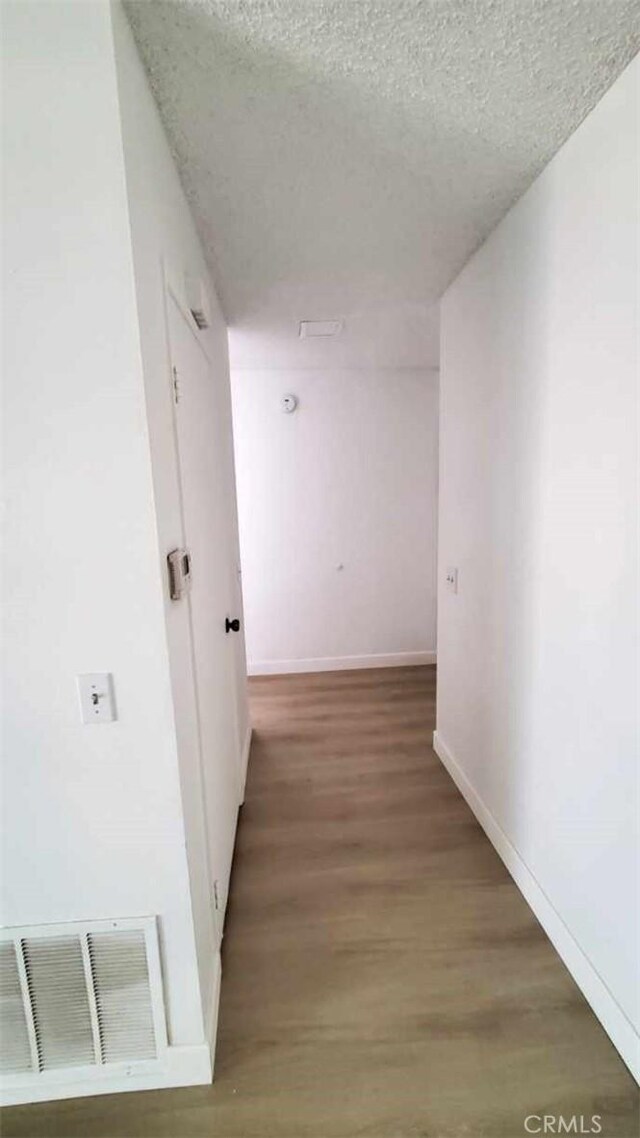 17070 Colima Rd Unit 284, Hacienda Heights, CA 91745 - corridor featuring a textured ceiling, wood finished floors, and baseboards