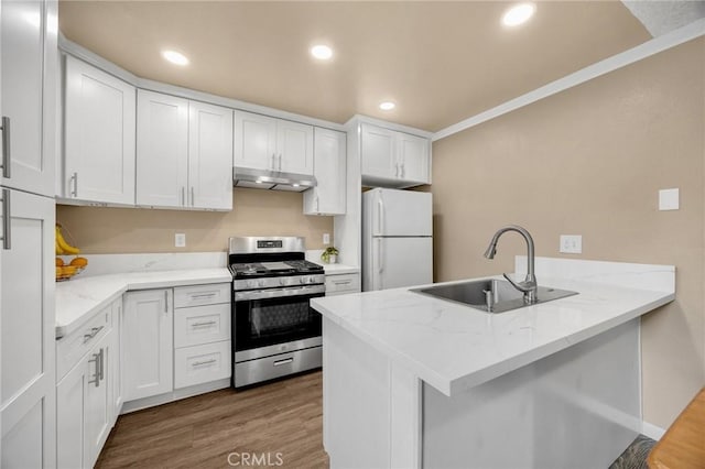 18241 Via Calma Unit 1, Rowland Heights, CA 91748 - kitchen featuring freestanding refrigerator, stainless steel range with gas cooktop, under cabinet range hood, a peninsula, and wood finished floors