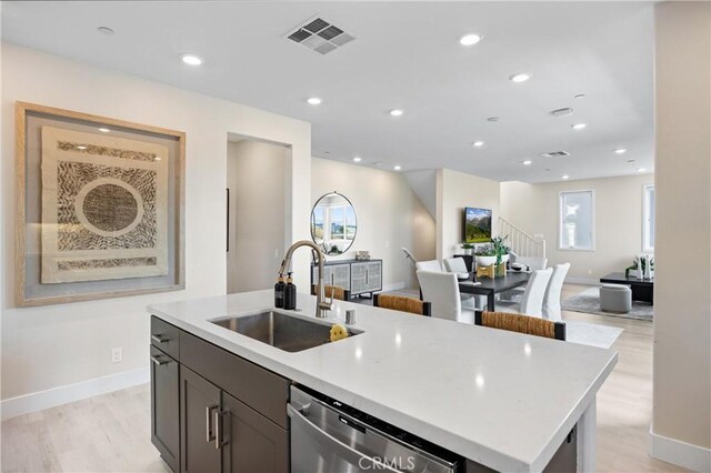 225 Waypoint, Tustin, CA 92782 - kitchen featuring a sink, dishwasher, open floor plan, an island with sink, and baseboards