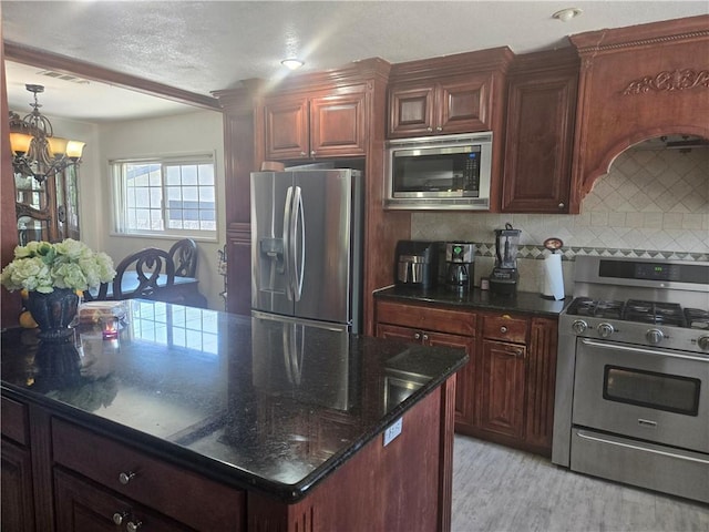 8335 True Ave, Pico Rivera, CA 90660 - kitchen featuring appliances with stainless steel finishes, a chandelier, tasteful backsplash, light wood-style floors, and dark stone countertops