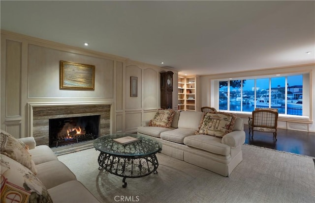 1100 Polaris Dr, Newport Beach, CA 92660 - living room featuring a decorative wall, built in shelves, wood finished floors, a premium fireplace, and recessed lighting