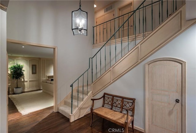 1100 Polaris Dr, Newport Beach, CA 92660 - staircase with wood finished floors, a high ceiling, a chandelier, and a decorative wall