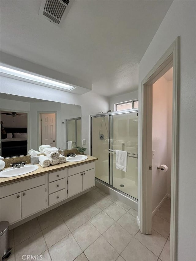 12390 San Dimas St, Victorville, CA 92392 - bathroom featuring double vanity, tile patterned floors, and a shower stall