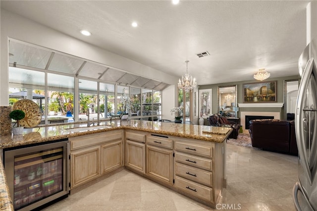 950 Chantel Dr, Corona, CA 92879 - kitchen featuring beverage cooler, light brown cabinets, open floor plan, light stone counters, and a fireplace