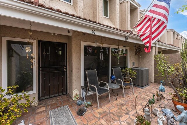 46 Lincoln Ct, Buena Park, CA 90620 - doorway to property with a patio area, cooling unit, and stucco siding