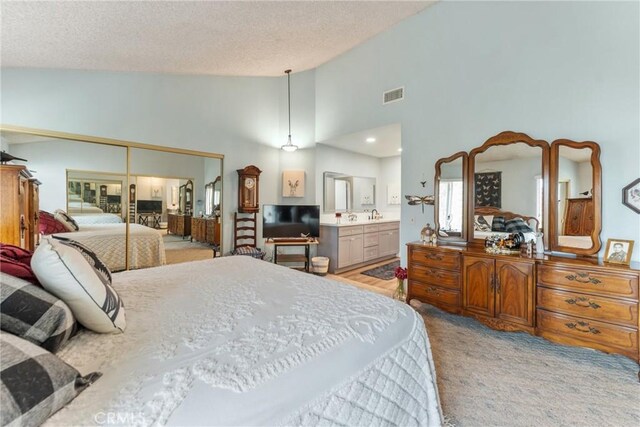 46 Lincoln Ct, Buena Park, CA 90620 - bedroom with a textured ceiling, light carpet, a closet, high vaulted ceiling, and ensuite bath