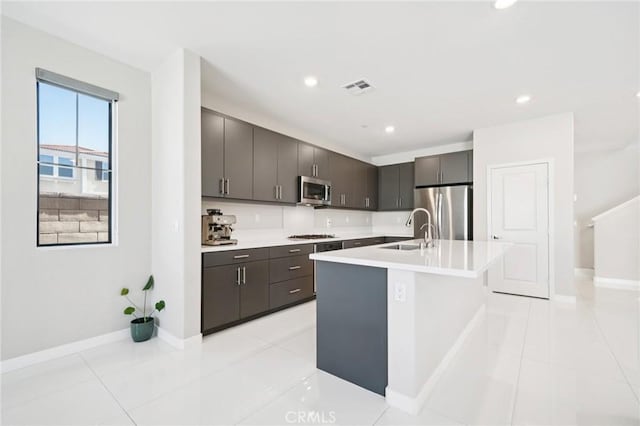 16773 Grapefruit Ln, Fontana, CA 92336 - kitchen featuring stainless steel appliances, light countertops, recessed lighting, an island with sink, and light tile patterned floors