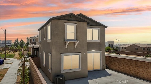 16773 Grapefruit Ln, Fontana, CA 92336 - back of property at dusk featuring stucco siding, a patio area, and central air condition unit