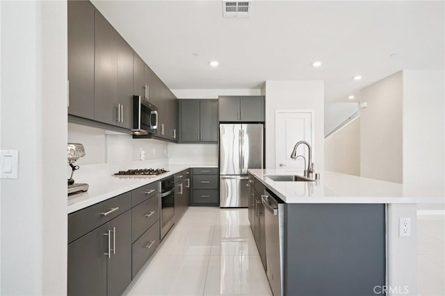 16773 Grapefruit Ln, Fontana, CA 92336 - kitchen with stainless steel appliances, a kitchen island with sink, light countertops, light tile patterned floors, and recessed lighting