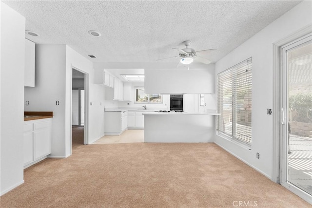 30369 Colina Verde St, Temecula, CA 92592 - kitchen with oven, light colored carpet, white cabinets, ceiling fan, and a textured ceiling