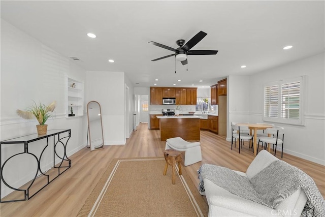 5322 Briercrest Ave, Lakewood, CA 90713 - living room with light wood finished floors, ceiling fan, recessed lighting, and built in shelves