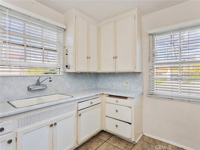 517 N Avon St, Burbank, CA 91505 - kitchen featuring a sink, light tile patterned floors, light countertops, and white cabinetry
