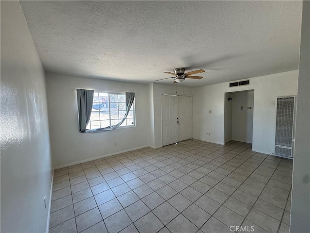 255 W Grace St, Barstow, CA 92311 - unfurnished bedroom with a heating unit, light tile patterned flooring, a textured ceiling, ceiling fan, and a closet