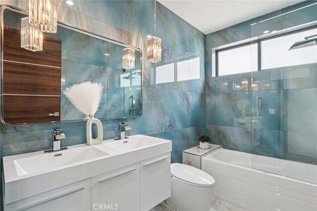 2227 N Lamer St, Burbank, CA 91504 - bathroom with tile walls, marble look tile flooring, a chandelier, double vanity, and backsplash