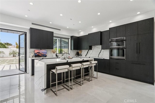 2227 N Lamer St, Burbank, CA 91504 - kitchen with dark cabinets, recessed lighting, a breakfast bar area, light countertops, and modern cabinets