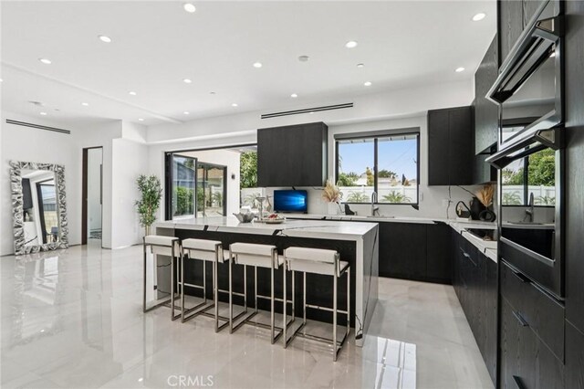2227 N Lamer St, Burbank, CA 91504 - kitchen with modern cabinets, dark cabinetry, recessed lighting, light countertops, and a kitchen island