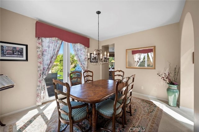 3262 Bluebird Cir, Simi Valley, CA 93063 - dining area featuring carpet flooring, a chandelier, baseboards, and arched walkways