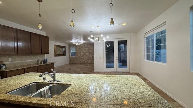 345 W Saint Andrews St, Ontario, CA 91762 - kitchen featuring hanging light fixtures, light stone counters, dark brown cabinetry, french doors, and a chandelier