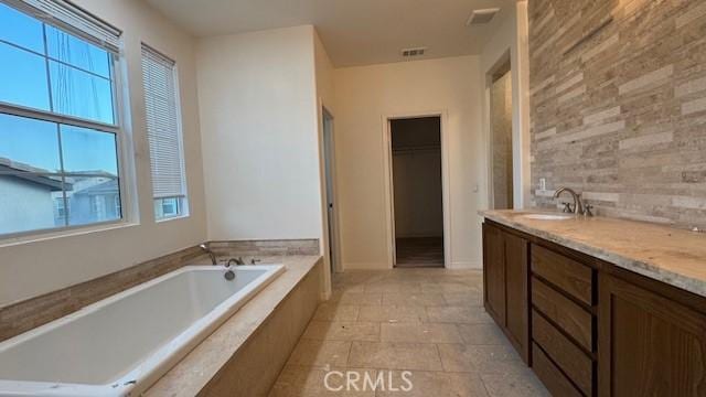 345 W Saint Andrews St, Ontario, CA 91762 - bathroom with healthy amount of natural light, a garden tub, double vanity, and stone finish flooring